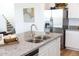 Modern kitchen features a stainless steel fridge, a granite countertop, and a stainless steel sink at 5916 S Daisy Patch Pl, Phoenix, AZ 85040