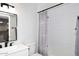 A neutral bathroom featuring white tiling, black hardware and printed shower curtain at 5942 N 83Rd St, Scottsdale, AZ 85250