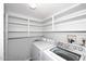 Bright laundry room with shelves and washer-dryer units at 5942 N 83Rd St, Scottsdale, AZ 85250