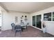 Covered patio with brick flooring, sliding glass door, and decorative wall art at 5942 N 83Rd St, Scottsdale, AZ 85250