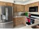 Well-lit kitchen with wood cabinets, stainless steel refrigerator, granite countertops, and modern appliances at 6122 E Saddleback St, Mesa, AZ 85215