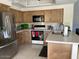 Cozy kitchen with stainless steel refrigerator, wood cabinets, and granite countertops, with bar seating at 6122 E Saddleback St, Mesa, AZ 85215
