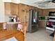 Cozy kitchen with stainless steel refrigerator, light wood cabinetry and tile floors at 6122 E Saddleback St, Mesa, AZ 85215