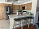 Bright kitchen showcasing wood cabinets, stainless steel appliances, a breakfast bar and stone countertops at 6122 E Saddleback St, Mesa, AZ 85215