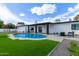 Backyard oasis with a sparkling pool, manicured turf, and an outdoor seating area, ideal for leisure and entertainment at 6539 E Sharon Dr, Scottsdale, AZ 85254
