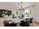 Sunlit dining room with modern chandelier and large windows offering views of the landscaped outdoor spaces at 6539 E Sharon Dr, Scottsdale, AZ 85254