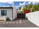 Gated driveway with gravel, concrete pavers, and xeriscape landscaping creates a striking and low-maintenance entry at 6539 E Sharon Dr, Scottsdale, AZ 85254