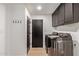 Functional laundry room includes a washer, dryer, cabinets, and storage hooks on the wall at 6539 E Sharon Dr, Scottsdale, AZ 85254