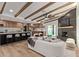 Open-concept living area featuring wood-look floors, beamed ceilings, and a view of the modern kitchen at 6539 E Sharon Dr, Scottsdale, AZ 85254