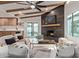 Cozy living room with wood-look tile flooring, beamed ceilings, fireplace and view to the outdoor pool at 6539 E Sharon Dr, Scottsdale, AZ 85254
