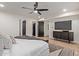 Comfortable main bedroom features a ceiling fan, TV, closet and en-suite bathroom at 6539 E Sharon Dr, Scottsdale, AZ 85254