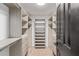 Spacious walk-in closet with custom shelving, drawers, and wood-look tile flooring at 6539 E Sharon Dr, Scottsdale, AZ 85254