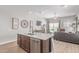 Open-concept kitchen island with stainless steel dishwasher and a view into the living area at 681 W Belmont Red Trl, San Tan Valley, AZ 85143