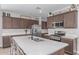 Well-lit kitchen features custom cabinetry, stainless steel appliances, and a large island with seating at 681 W Belmont Red Trl, San Tan Valley, AZ 85143