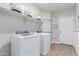 Bright laundry room featuring a modern washer, dryer, floating shelf and neutral wall color at 681 W Belmont Red Trl, San Tan Valley, AZ 85143