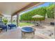 Backyard features green lawn, patio area, seating, shade trees and a fire pit at 6870 S Justin Way, Chandler, AZ 85249
