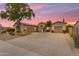 Beautiful single-story home boasts a circular driveway, desert landscaping, and a three-car garage at sunset at 6870 S Justin Way, Chandler, AZ 85249