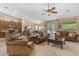 Cozy living room with leather sofas, a ceiling fan, and an adjacent kitchen and dining area at 6870 S Justin Way, Chandler, AZ 85249