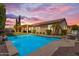 Beautiful backyard pool at dusk, with a covered patio and mature landscaping, perfect for relaxation and entertaining at 6870 S Justin Way, Chandler, AZ 85249