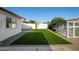 Large backyard with artificial turf, a white block fence, mature trees, and a storage shed at 7425 W Corrine Dr, Peoria, AZ 85381