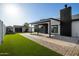 Backyard featuring artificial grass, concrete walkway, patio, and well maintained landscaping at 7425 W Corrine Dr, Peoria, AZ 85381