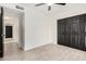 A well lit bedroom with neutral paint, wood-look tile flooring, and a closet with dark paneled doors at 7425 W Corrine Dr, Peoria, AZ 85381