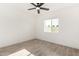 Light-filled bedroom with a ceiling fan, wood look floors, and a window offering views of the outside at 7425 W Corrine Dr, Peoria, AZ 85381
