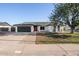 Charming single-story home with a well-maintained front yard, a black garage door, and a red front door at 7425 W Corrine Dr, Peoria, AZ 85381