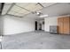Spacious garage area with painted walls and floors, storage cabinets, and a garage door at 7425 W Corrine Dr, Peoria, AZ 85381