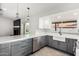 Modern kitchen featuring a farmhouse sink, and a view of the fireplace in the living area at 7425 W Corrine Dr, Peoria, AZ 85381