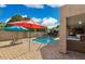 Serene backyard featuring a pool, hot tub, lounge chairs, and a fully equipped outdoor kitchen at 7457 W Crystal Rd, Glendale, AZ 85308