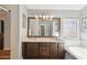 Well-lit bathroom showcasing double vanity, large mirror, decorative lighting, and soaking tub at 7457 W Crystal Rd, Glendale, AZ 85308