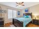 Cozy bedroom with bright bedding, wood floors, and a large window with blinds at 7457 W Crystal Rd, Glendale, AZ 85308