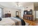 Comfortable bedroom featuring wood floors, ceiling fan, TV, dresser and stylish furniture at 7457 W Crystal Rd, Glendale, AZ 85308