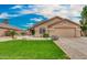 Charming single-story home features a lush green lawn and low-maintenance desert landscaping at 7457 W Crystal Rd, Glendale, AZ 85308