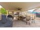 Entertainer's dream: covered outdoor kitchen with grill, mini fridge, TV, and bar seating for ultimate outdoor enjoyment at 7457 W Crystal Rd, Glendale, AZ 85308