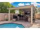 Stylish outdoor kitchen with a built-in grill, bar seating, and a cozy covered patio area at 7457 W Crystal Rd, Glendale, AZ 85308