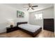 Cozy bedroom featuring a ceiling fan, wooden floors, and a neutral color palette at 7665 E Montecito Ave, Scottsdale, AZ 85251