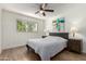 A comfortable bedroom, wood floors, a window, and neutral decor with accent lighting at 7665 E Montecito Ave, Scottsdale, AZ 85251