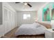 Bedroom featuring wood floors, a ceiling fan, a window and closet with folding doors, plus neutral decor at 7665 E Montecito Ave, Scottsdale, AZ 85251