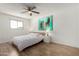 Bright bedroom with wood floors, ceiling fan, minimalist furniture, and a captivating teal wall art piece at 7665 E Montecito Ave, Scottsdale, AZ 85251