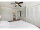 Bright bedroom showcasing wood floors, ceiling fan, closet with folding doors, and entry to the bathroom at 7665 E Montecito Ave, Scottsdale, AZ 85251
