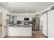 Modern kitchen with stainless steel appliances, white cabinets, and a breakfast bar at 7665 E Montecito Ave, Scottsdale, AZ 85251