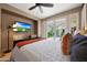 Bright main bedroom featuring a ceiling fan, television, and glass doors to the patio at 7705 E Doubletree Ranch Rd # 8, Scottsdale, AZ 85258