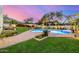 Beautiful backyard with a sparkling pool, lush landscaping, and an outdoor kitchen area at 7838 N 54Th Pl, Paradise Valley, AZ 85253
