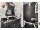 Stylish powder room with black vanity, dark walls, and custom mirror at 7838 N 54Th Pl, Paradise Valley, AZ 85253