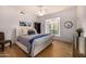Bright bedroom featuring hardwood floors, tufted headboard, window seat, and custom shelving at 7838 N 54Th Pl, Paradise Valley, AZ 85253