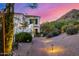 Landscaped desert yard with exterior lighting leading to a beautiful white home with mountain views at dusk at 7838 N 54Th Pl, Paradise Valley, AZ 85253