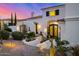 Beautiful white home with desert landscaping, a clay tile roof, and a decorative iron door at dusk at 7838 N 54Th Pl, Paradise Valley, AZ 85253