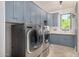 Well-equipped laundry room with modern washer and dryer, blue cabinetry and sink at 7838 N 54Th Pl, Paradise Valley, AZ 85253